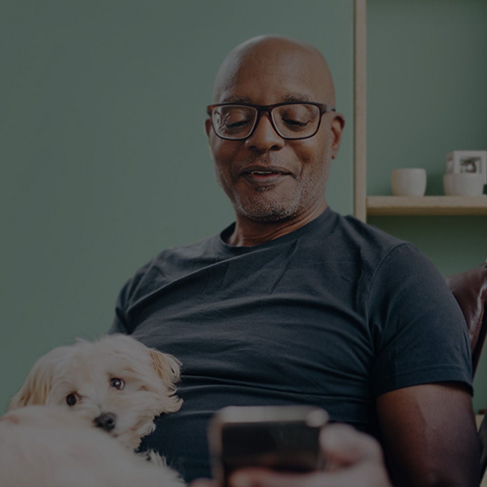   gammal man sitter med en hund i knät